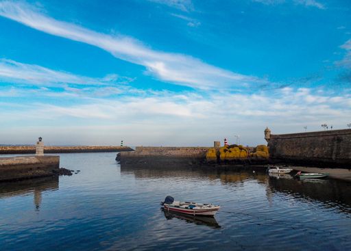 A scenic view of the calm coast near the city of Cadiz in Portugal under a wispy sky