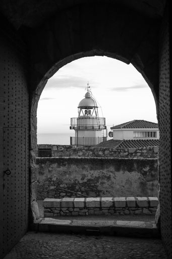 Peniscola Lighthouse As Seen From The Arched Balcony and Castle In The Old Peniscola Town, Castellon, Spain. September 2021. Vertical shot.