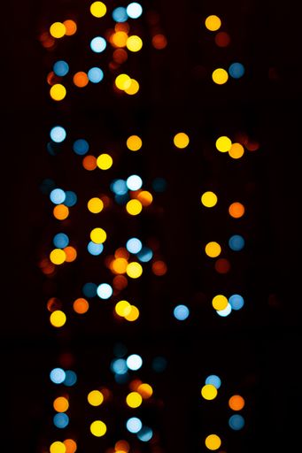 A dark blurry background with colorful bokeh lights for textures and wallpapers
