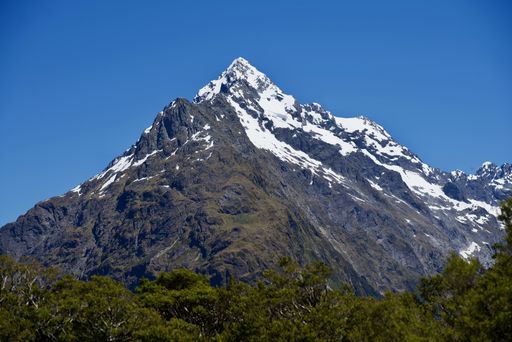 A beautiful day in the Fiordland National Park with snow covering the top of a big mountain