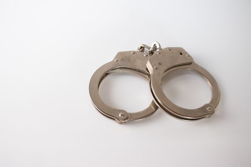 A high angle shot of metal handcuffs isolated on a white background