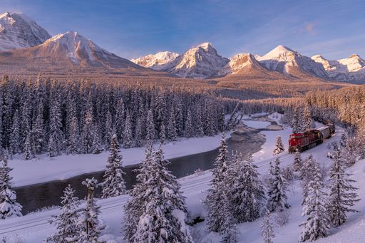 Beautiful sunrise in winter at Morant's Curve in Banff National Park, Alberta, Canada with a train.