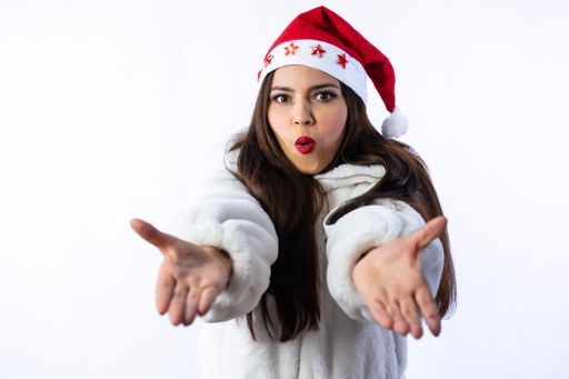 A pretty female in a Santa hat looking at the camera and posing