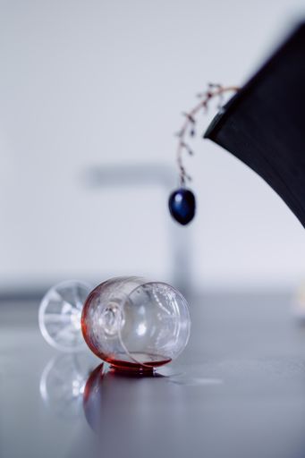 A vertical shot of a grape and a spilled wine on a table