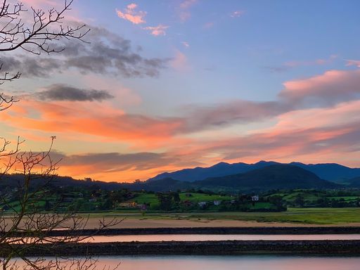 A beautiful view of a field with mountains during sunrise