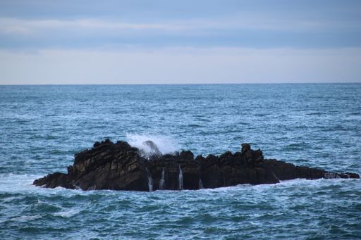 A beautiful view of the wavy sea hitting the rocky cliffs on the coast