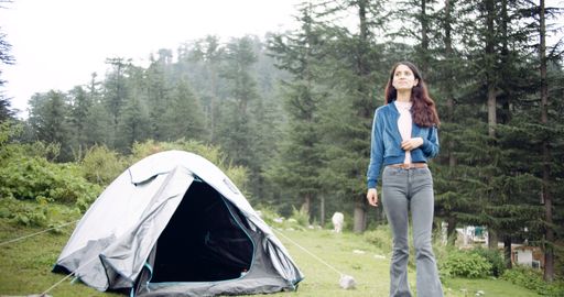 A young Indian girl near a tent while hiking