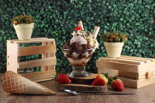 A closeup of amazing ice cream preparation with chocolate, strawberry and natural background