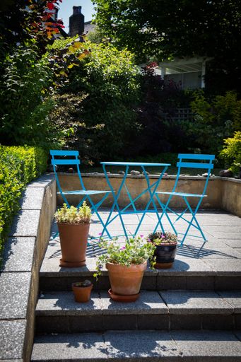 A vertical shot of a beautiful patio with table and chairs.