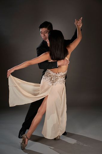 A Latin female and an Asian male dancing tango
