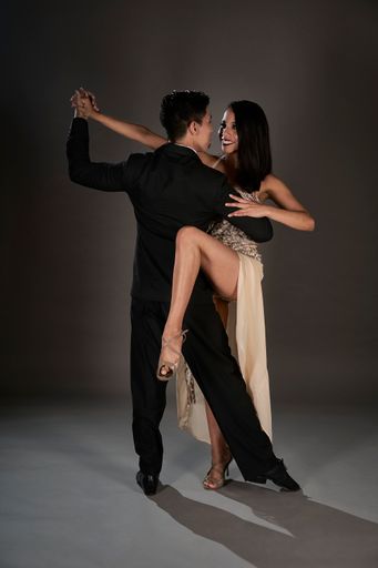 A Latin female and an Asian male dancing tango