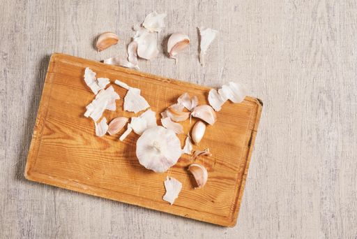 A top view of the cleaning organic garlic on the cutting board in the kitchen