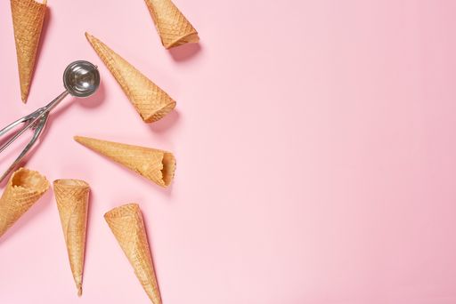 A top view shot of ice cream cones on a pink background with copy space