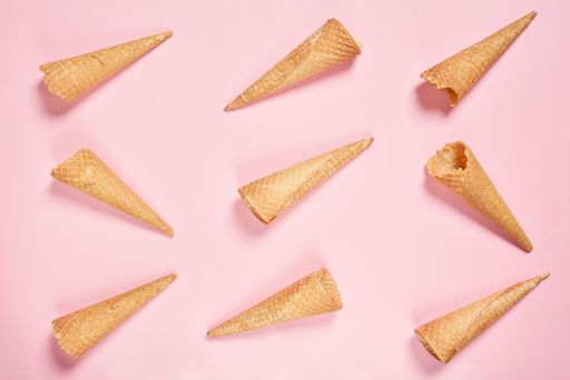 A top view shot of ice cream cones on a pink background with copy space