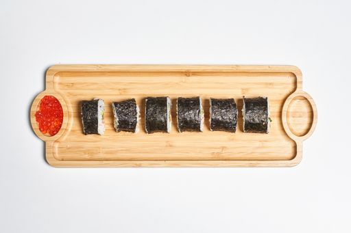 A top view of the fresh and appetizing maki sushi rolls served with red caviar on a wooden plate