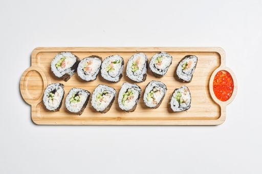 The fresh and appetizing maki sushi rolls served with red caviar on a wooden plate