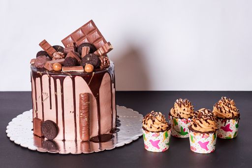 A closeup shot of a delicious chocolate cake with little cupcakes