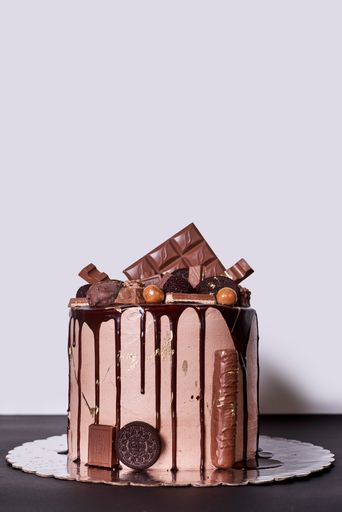A vertical shot of a tasty cake decorated with chocolate on the black surface