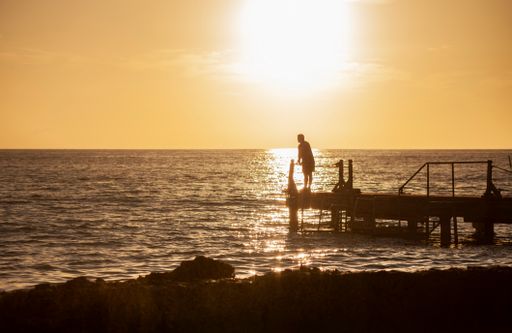 Fisherman on the pier at sunset in Bayahibe in the Dominican Republic