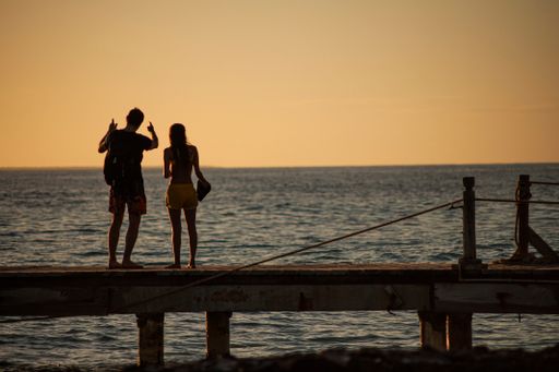 BAYAHIBE, DOMINICAN REPUBLIC 13 DECEMBER 2019: Young couple in love on the pier at susnset