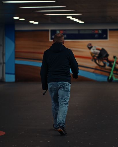 A vertical shot of the man walking in the parking lot.
