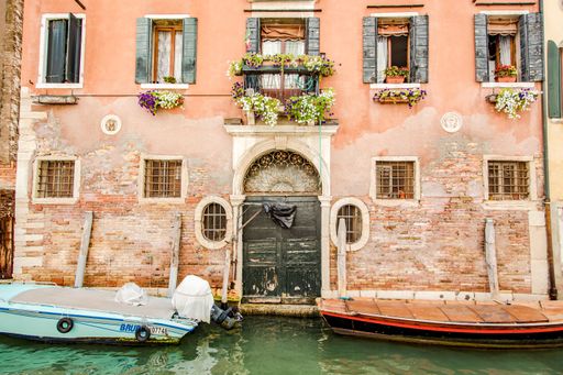 A beautiful shot of a narrow canal with a medieval building in Venice, Italy