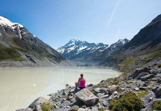 A caucasian woman looking to the distance at Hooker valley leading to Aoraki Mount Cook in New Zealand