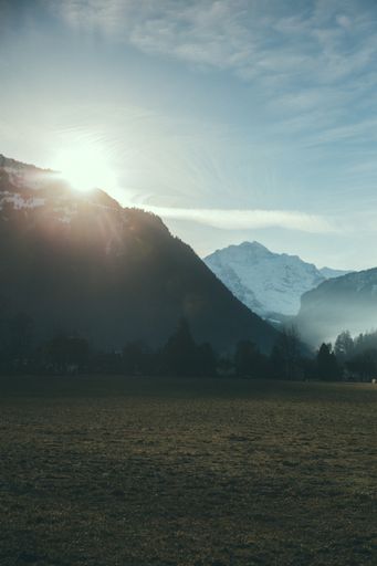 A vertical shot a bright sunset over mountains in Switzerland