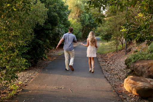 A back view of a happy couple walking in a park