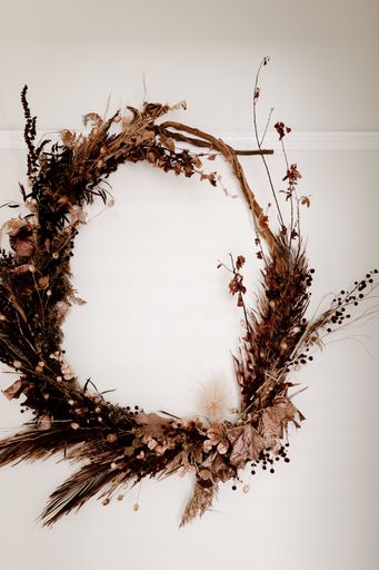 A vertical shot of a round twig wreath on a white surface