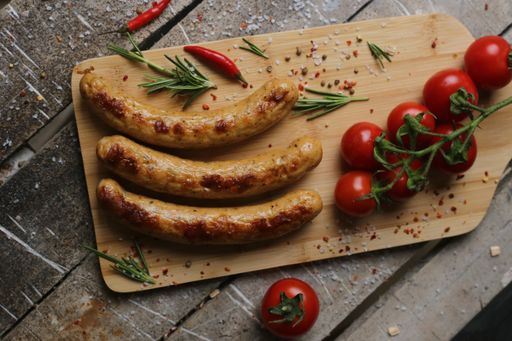 A top view of the grilled sausages with cherry tomatoes