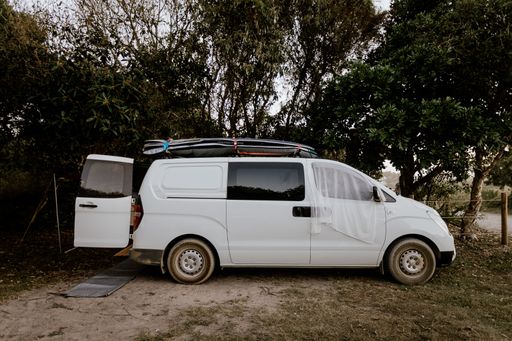 A close shot of a white van parked near trees
