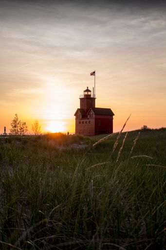 A vertical shot of the Holland Harbor Lighthouse during the sunset in Michigan