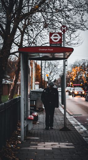 A view of a man at a bus station on a rainy day