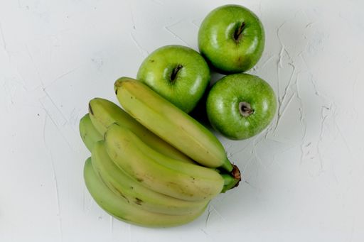 A top view of green apples and bananas isolated on white background