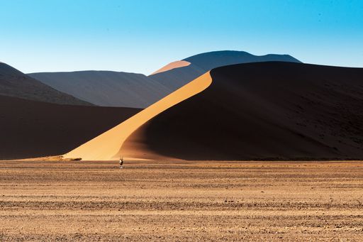 A beautiful picture of Namib National Park dunes and oryx against brown sand mountains - Perfect wallpaper for desktop