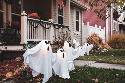 A house exterior decorated with ghosts on foliage leaves ready for Halloween