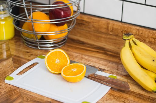 A closeup shot of a cut orange on a white cutting board