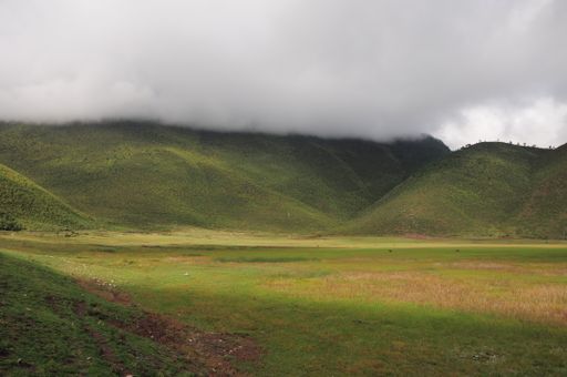 A landscape of hills covered in greenery and clouds on a rainy day in the countryside