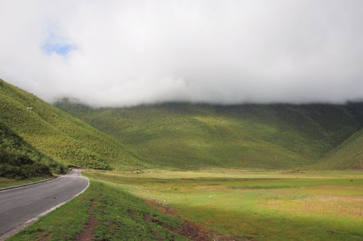 A landscape of hills covered in greenery and clouds on a rainy day in the countryside