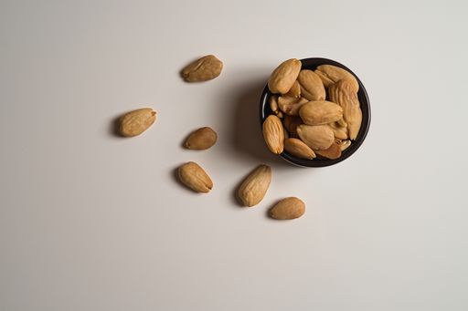 A top view of sunflower seeds in a small black bowl on white table