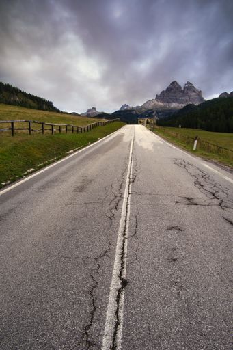 A shot of an empty asphalt road under cloudy sky in Dolomitas, Italy