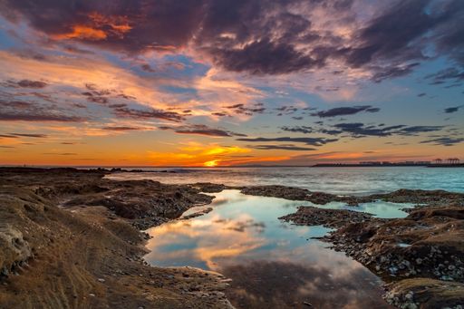 A beautiful view of the wavy Tasmanian Sea gleaming under the sunset on the coast
