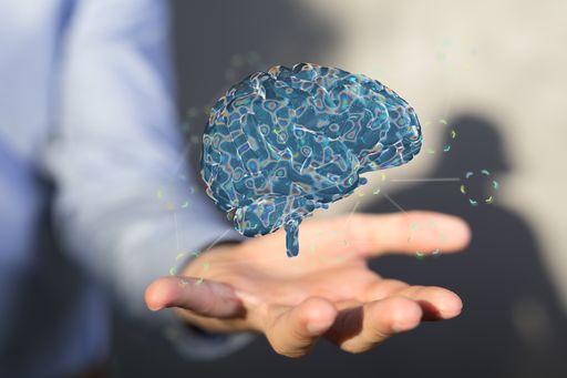 A 3D rendering of a blue glowing human brain floating in the air with a man holding a hand under it