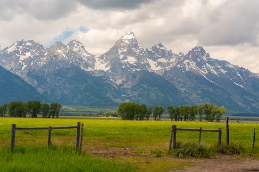 A natural view of a vast grassland in the countryside with a mountainous landscape background