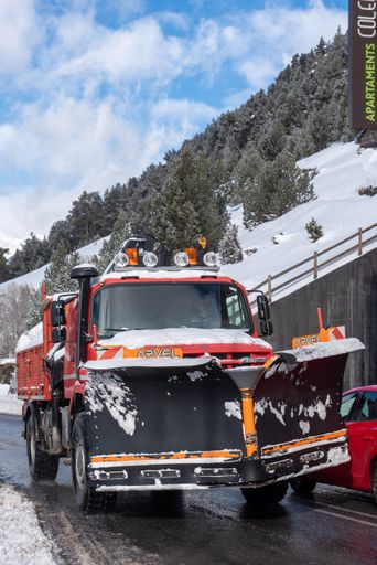 A vertical shot of a snowplow truck along the road in Canillo, Andorra