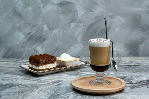 A cup of mocha and a slice of tiramisu dessert on a marble floor