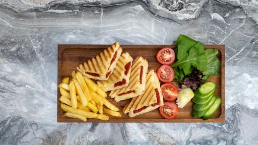 A top view shot of toast in a wooden serving platter on a marble background