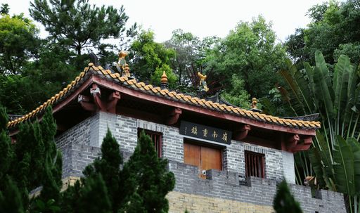 A low angle shot of a Chinese traditional building in a forest