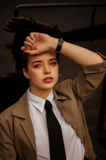 A beautiful young Hispanic girl in business clothing posing leaning on a mirror in Argentina